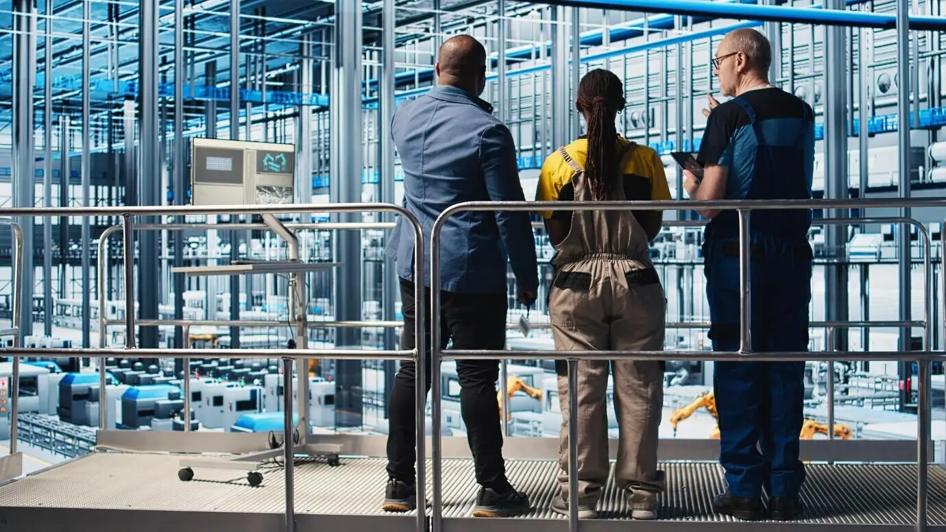 Gerente de planta fotovoltaica de Industria 4.0 en una plataforma industrial supervisando el trabajo realizado por los ingenieros para