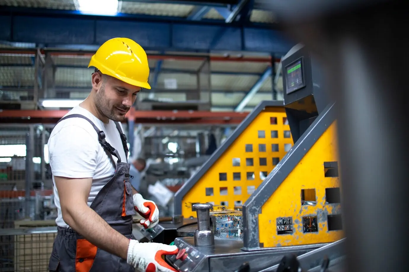 Retrato de un trabajador de fábrica trabajando en una máquina industrial en una planta de producción.